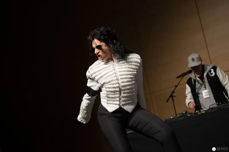 Performance Artist in White Striped Jacket Executing Dynamic Stage Movement