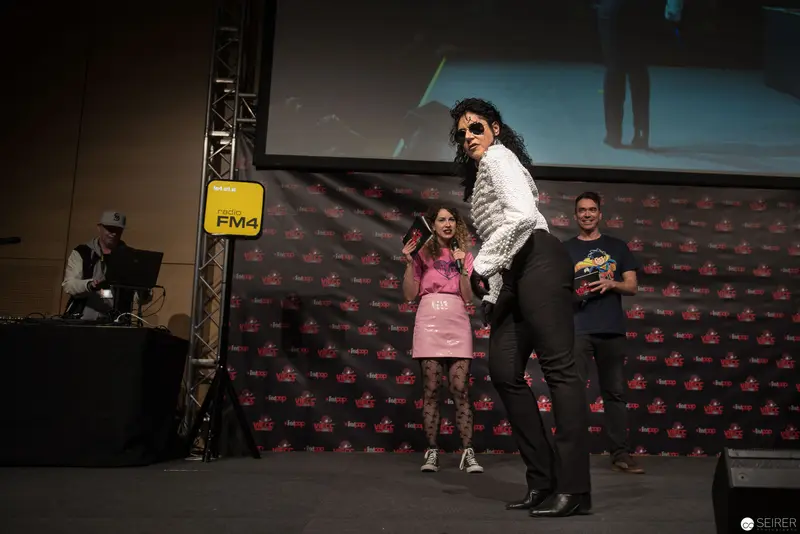 FM4 Stage Performance with Performer in White Jacket and Sunglasses