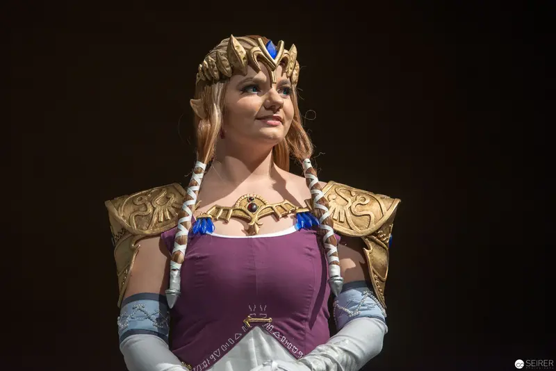 Costumed Performer in Regal Fantasy Attire with Ornate Crown and Shoulder Armor
