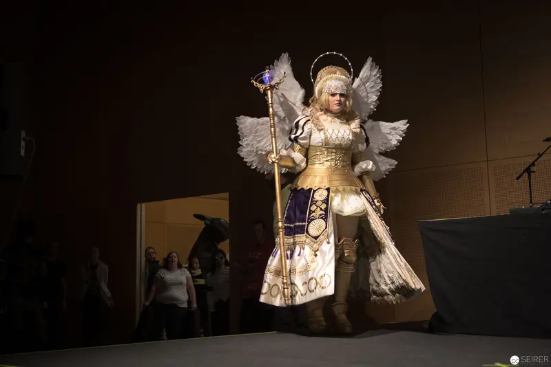 Angelic Cosplay Performance on Stage with Elaborate Winged Costume