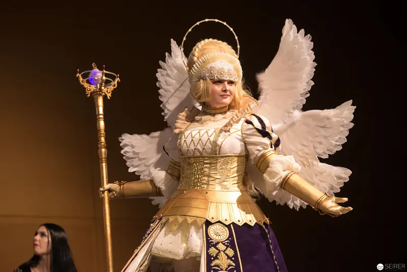 Angelic Costumed Figure with Winged Costume and Ornate Staff in Performance
