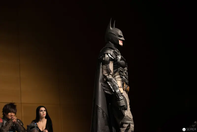 Batman Cosplay Figure in Dramatic Silhouette at Convention Event