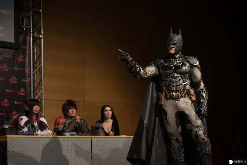 Batman Cosplayer in Dramatic Pose at Convention Panel Discussion