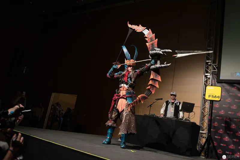 Costumed Performer with Elaborate Headdress Striking Dramatic Pose on Stage