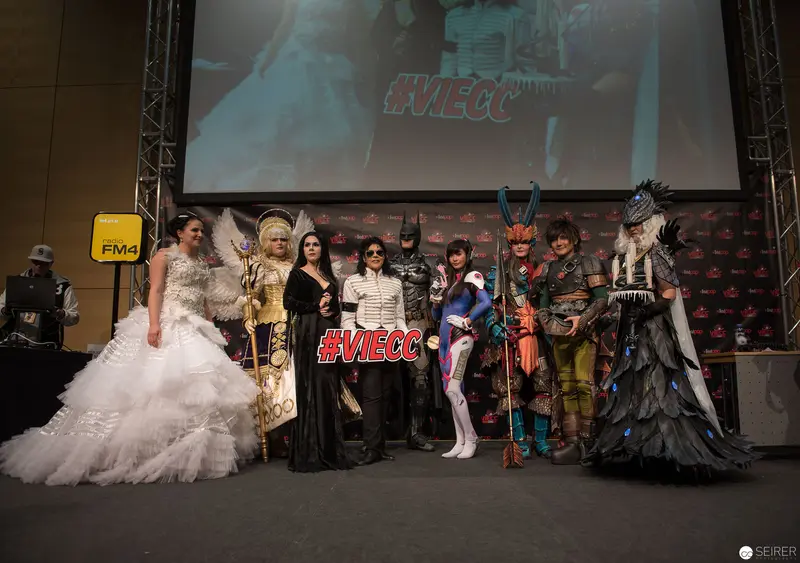 Cosplay Performers Pose with #VIECC Hashtag at Convention Stage