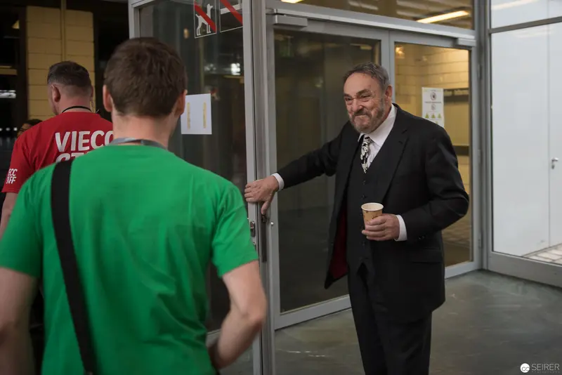Office Doorway Interaction Between Formally Dressed Man and Casual Staff Members