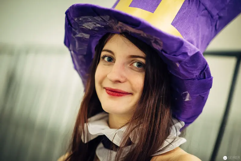 Young Woman in Vibrant Purple Witch Hat with Red Lipstick