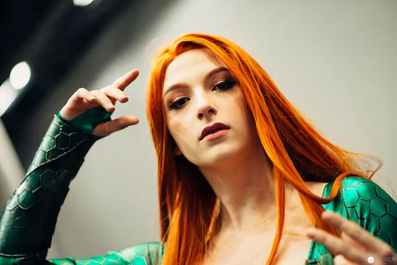 Vibrant Portrait of Woman in Green Textured Armor with Vivid Orange Hair