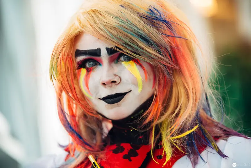 Vibrant Clown-Inspired Makeup Portrait with Multicolored Hair and Dramatic Facial Expression