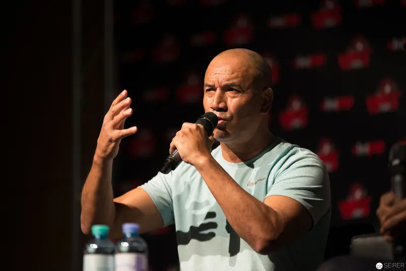 Bald Speaker Gesturing Intensely During Presentation at Press Conference