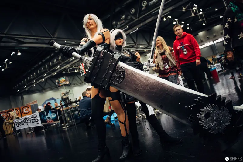 Cosplay Performance with Oversized Weapon at Convention Exhibition Hall
