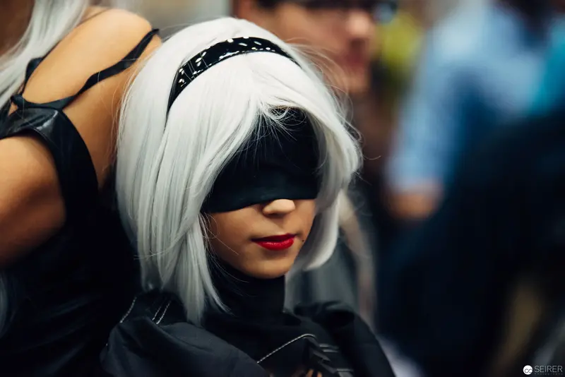 Cosplay Performance: White-Haired Figure in Black Mask and Leather