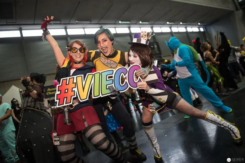 Cosplayers Posing with #VIECC Hashtag Sign at Vibrant Convention Event