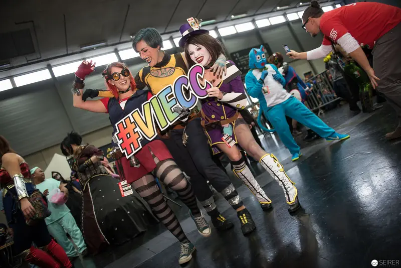 Cosplayers Striking Playful Pose with #VIECC Hashtag Sign at Convention