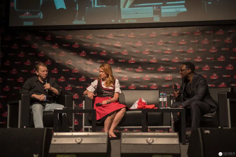 Panel Discussion at Entertainment Conference with Three Speakers on Stage