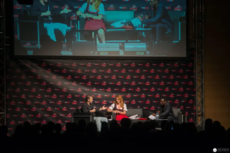 Panel Discussion at Fan Convention with Three Speakers on Stage