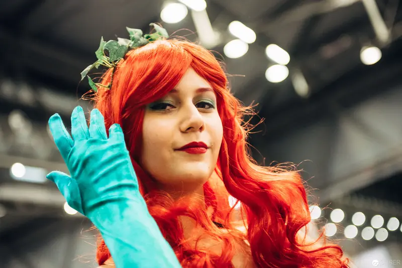 Cosplayer in Vibrant Orange Wig and Teal Gloves at Convention Event