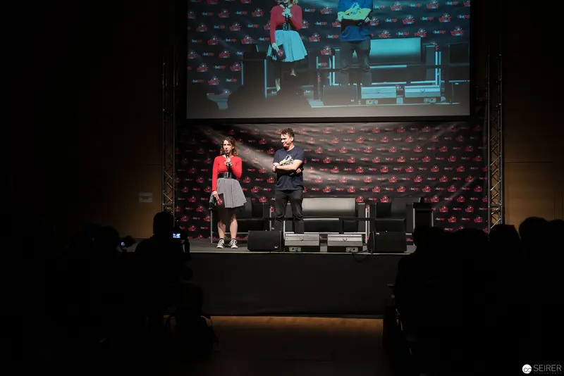 Stage Presentation with Red and Blue Backdrop at Media Event