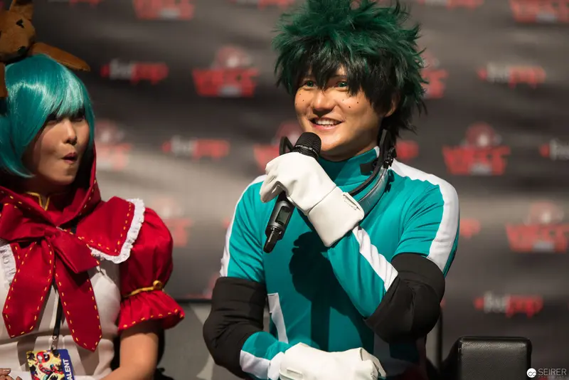 Cosplay Performance with Smiling Performer in Green and Teal Costume