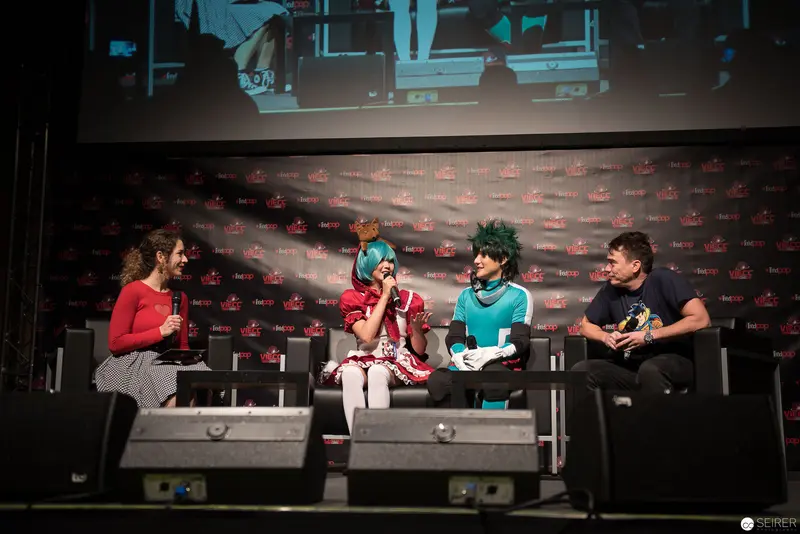 Comic Convention Panel Discussion with Cosplay Participants on Stage