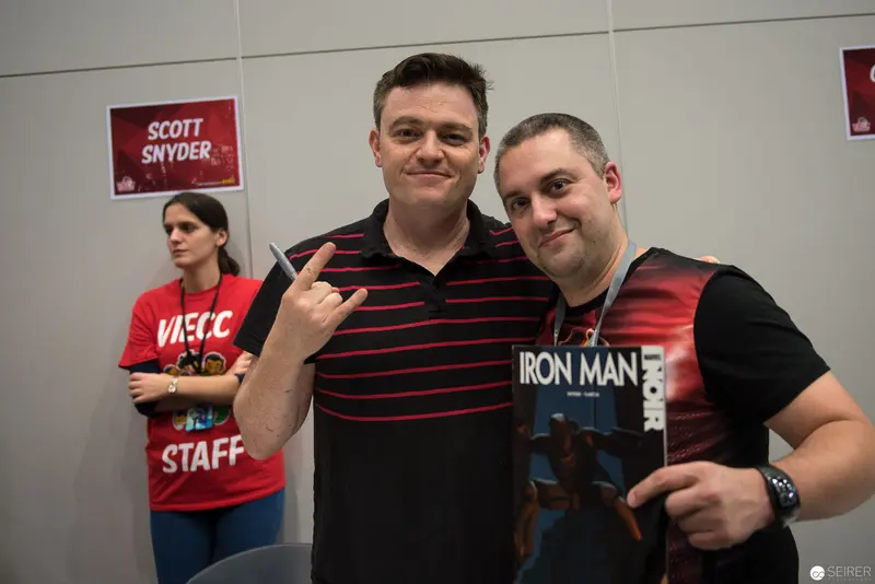 Two Men Pose with Staff at Convention Featuring Scott Snyder and Iron Man