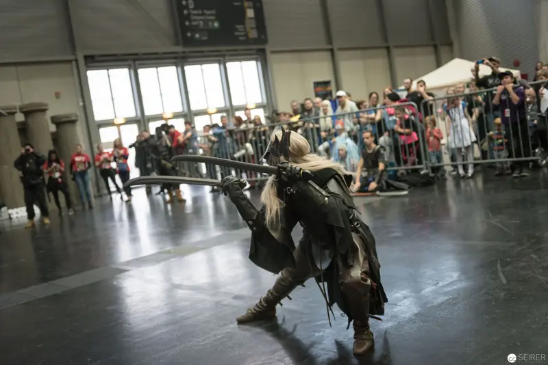 Klingenspiel Historic Fencing Performer in Dynamic Sword Stance at Indoor Exhibition
