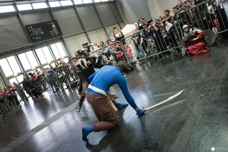 Klingenspiel Historic Fencing Performance: Blue-Clad Performer in Dynamic Combat Stance