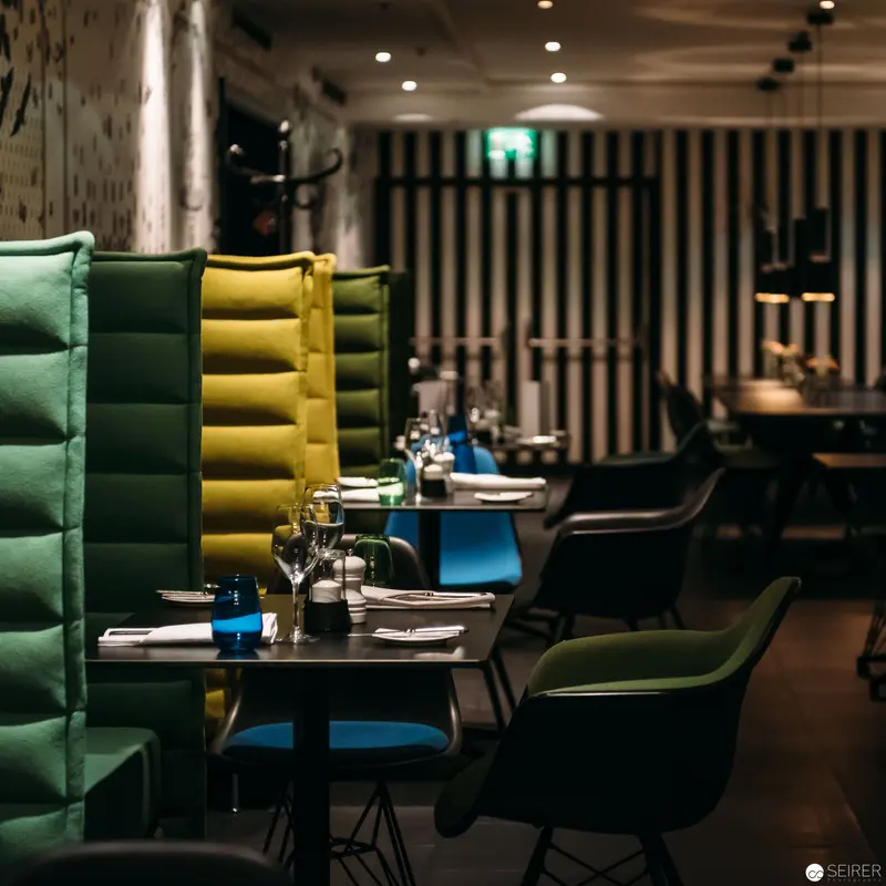 Modern Restaurant Interior with Geometric Green and Yellow Upholstered Seating