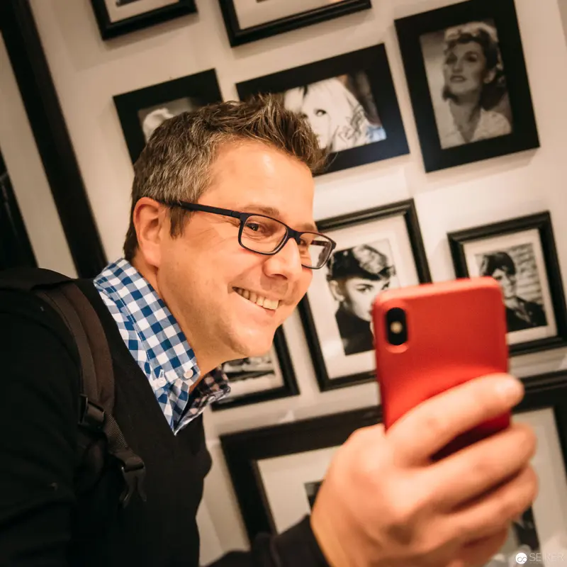 Smartphone Selfie in Vintage Photographic Gallery with Black and White Portraits