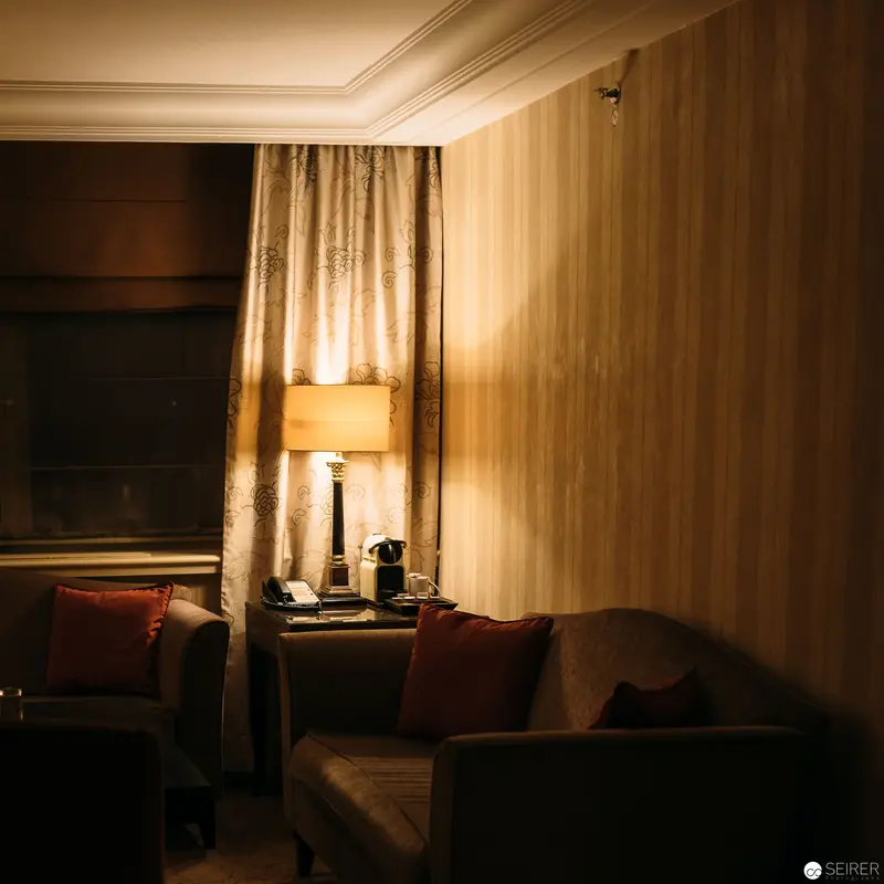 Intercontinental Hotel Room Interior: Warm Lamp and Shadowed Seating in Ambient Light