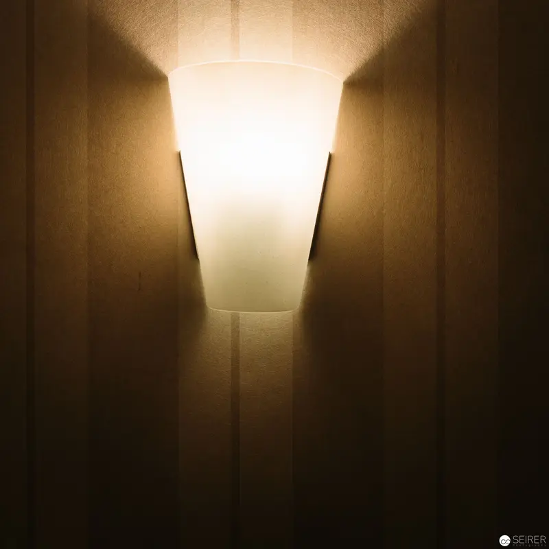 Architectural Wall Sconce with Soft Luminescent Glow in Warm Interior Setting