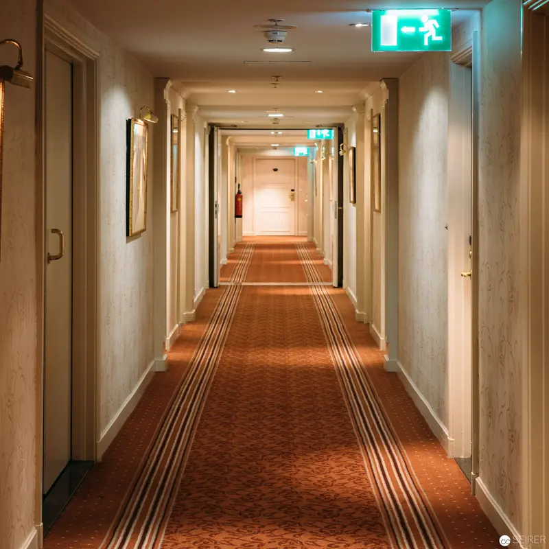 Hotel Intercontinental Corridor: Architectural Interior with Warm-Toned Carpeted Hallway