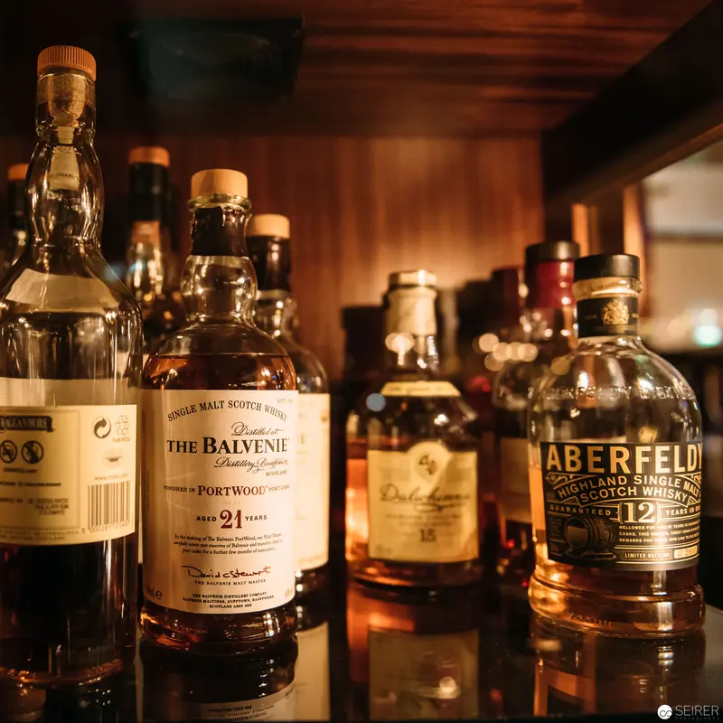Premium Scotch Whisky Collection in Warm, Intimate Wooden Setting