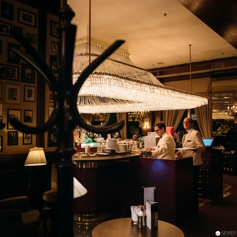 Hotel Intercontinental Bar: Luminous Crystal Chandelier and Bartenders at Work