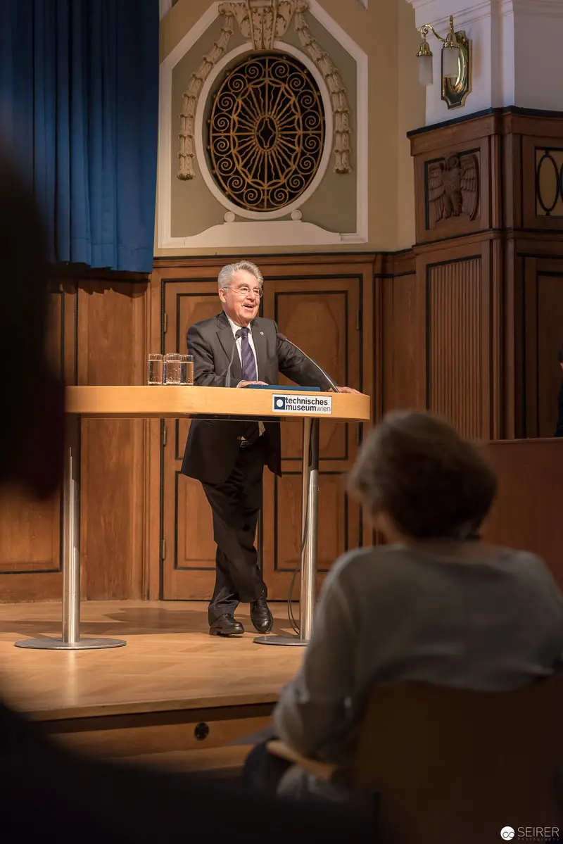 Lecturer at Podium Delivering Presentation in Ornate Architectural Setting