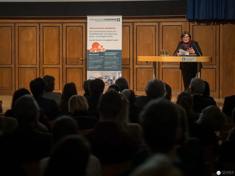 Academic Lecture on Austrian Media at Podium Event with Attentive Audience