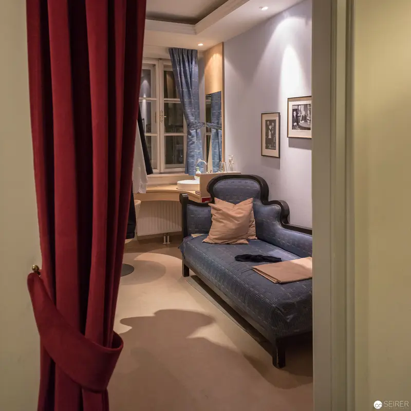 Intimate Interior View with Blue Chaise Longue and Crimson Curtain