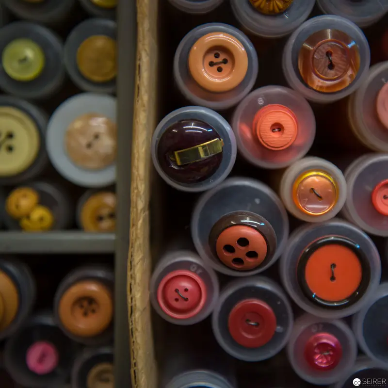 Organized Chromatic Array of Vintage Sewing Buttons in Wooden Storage Compartment
