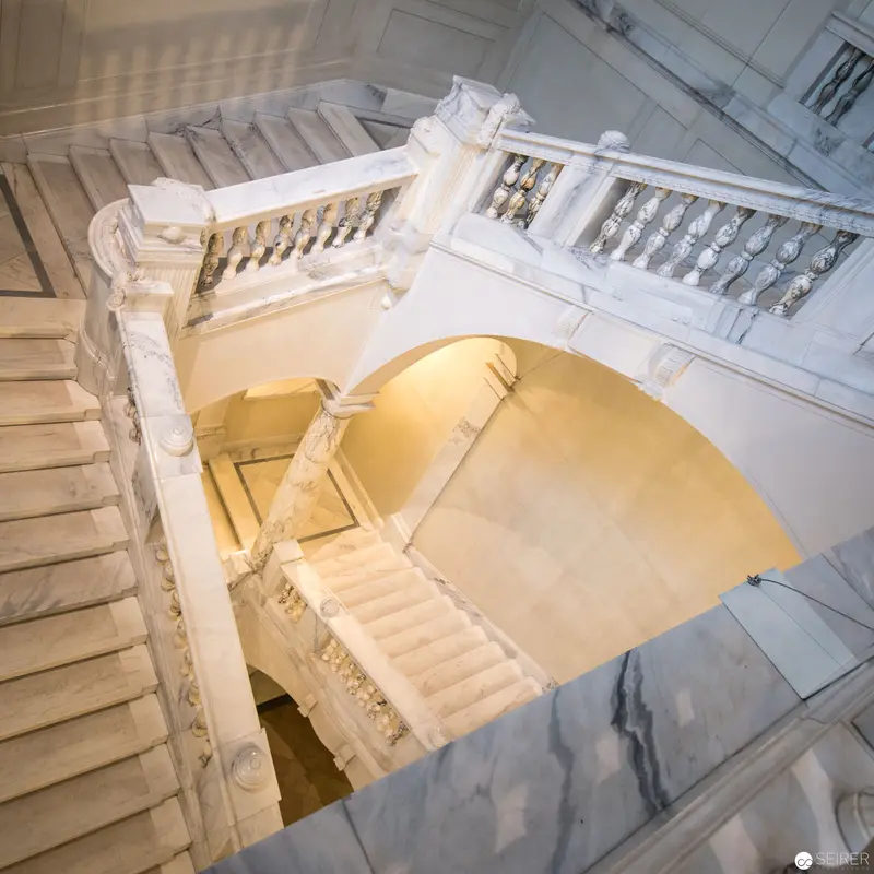 Elaborate Marble Staircase with Curved Arch and Ornate Balustrade