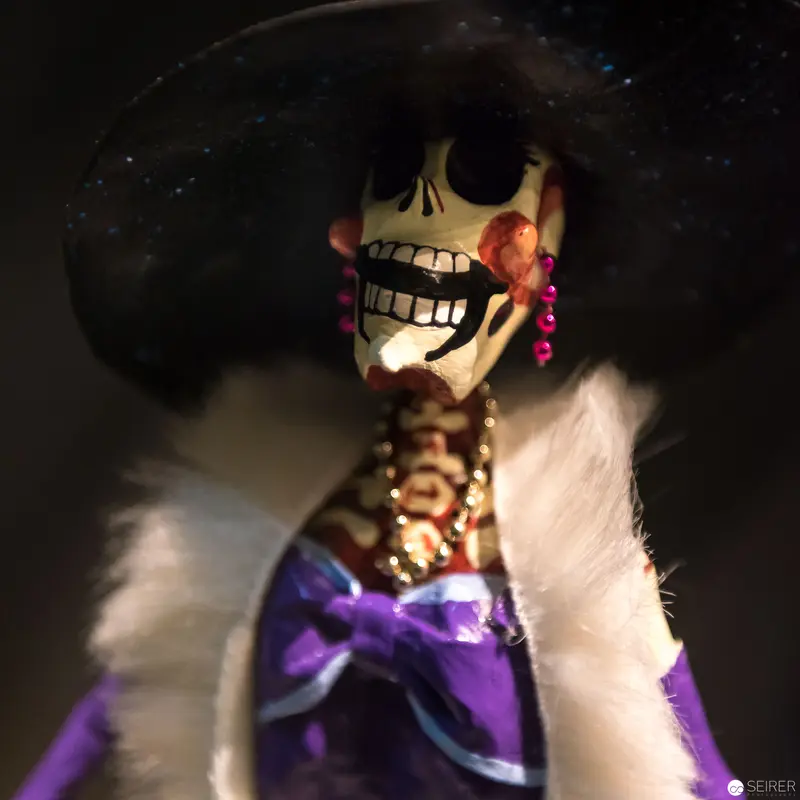 Ornate Day of the Dead Figurine with Skeletal Makeup and Purple Attire