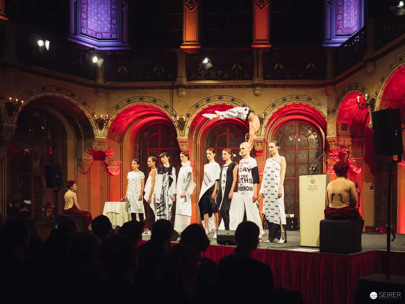 Fashion Models on Stage at Ornate Historic Venue with Dramatic Red and Purple Lighting