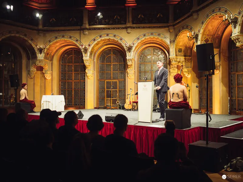 Formal Presentation on Ornate Stage with Red Draped Platform