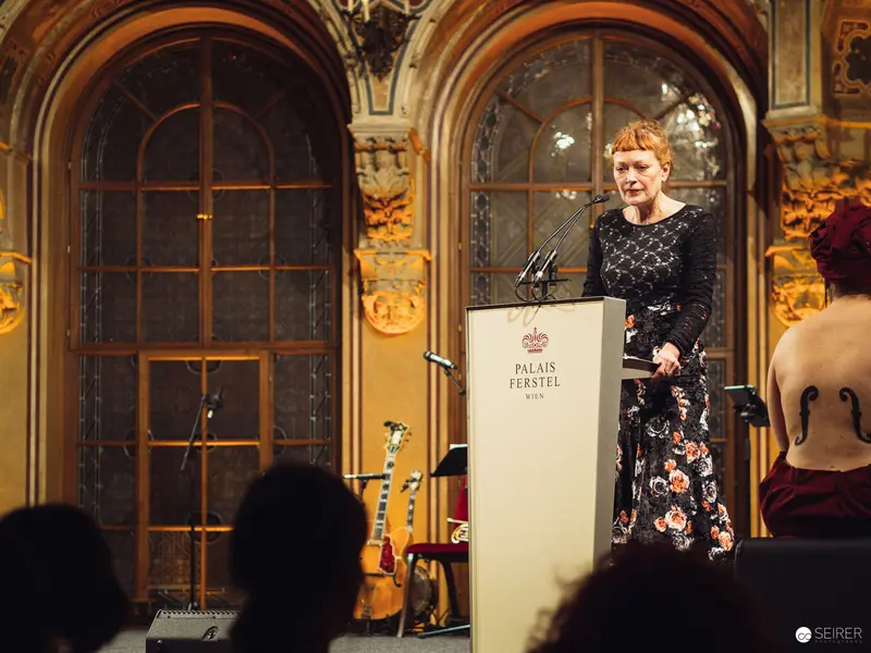 Keynote Speaker in Ornate Palais Ferstel, Wearing Floral Evening Attire