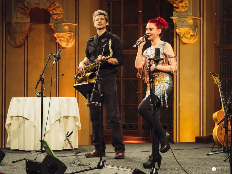 Musical Duo Performing with Saxophone and Microphone on Elegant Stage