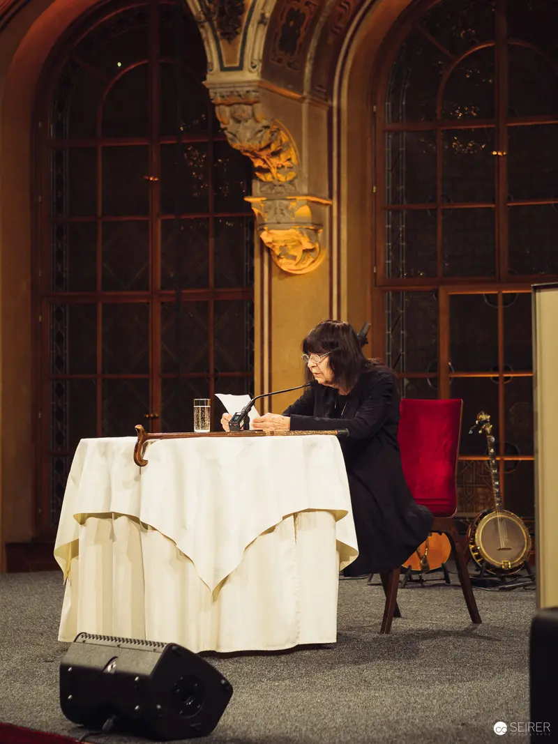 Solitary Figure at Elegantly Draped Table in Ornate Interior Setting