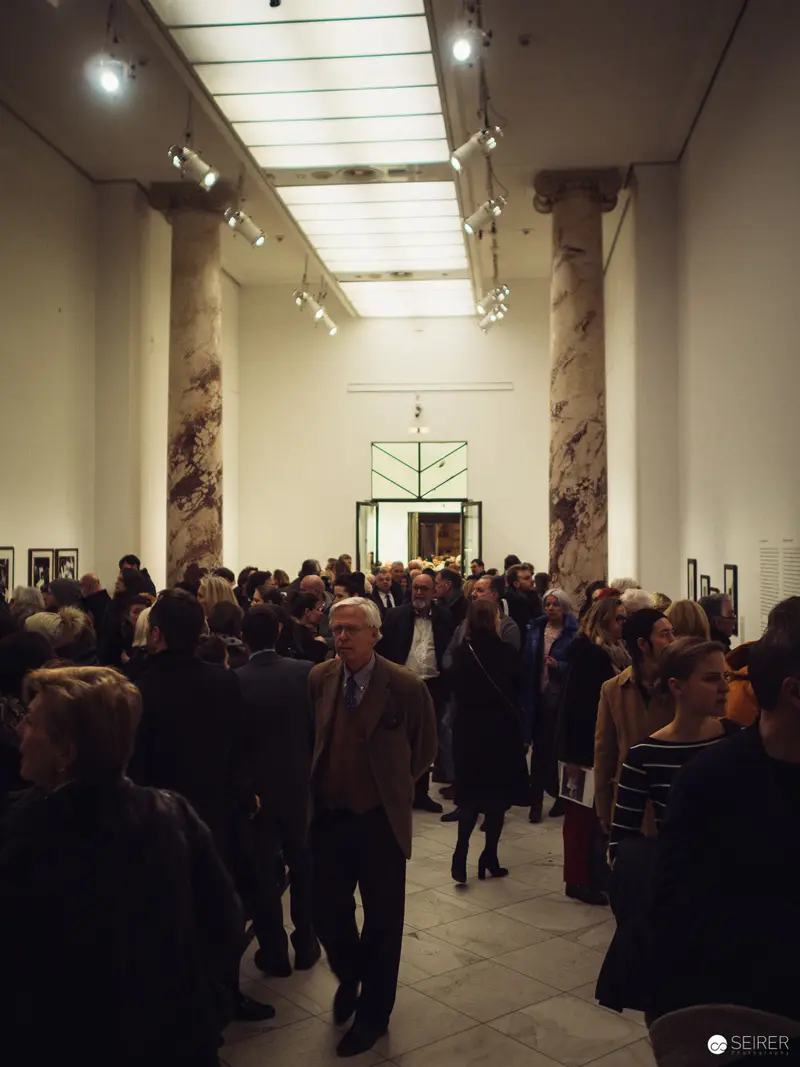 Gallery Opening Reception with Crowded Interior and Architectural Skylighting