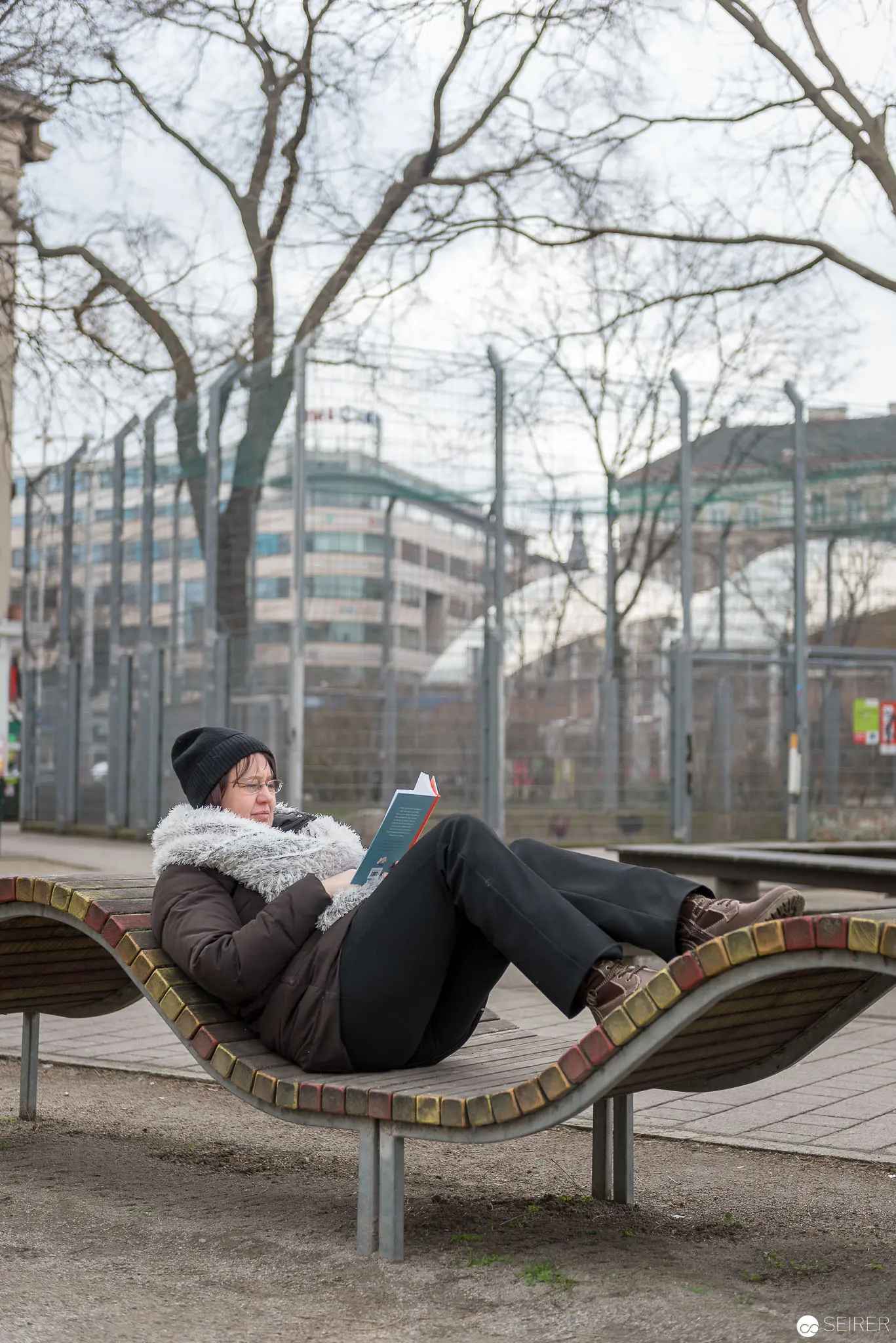 Janett Cernohuby Relaxing on Sculptural Urban Bench Near Vienna Public Library