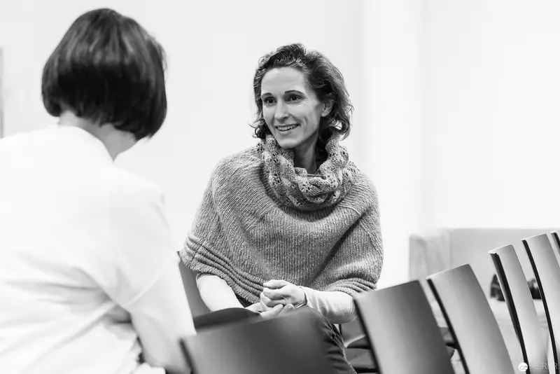 Melanie Laibl in Thoughtful Conversation, Seated in Minimalist Interior Setting