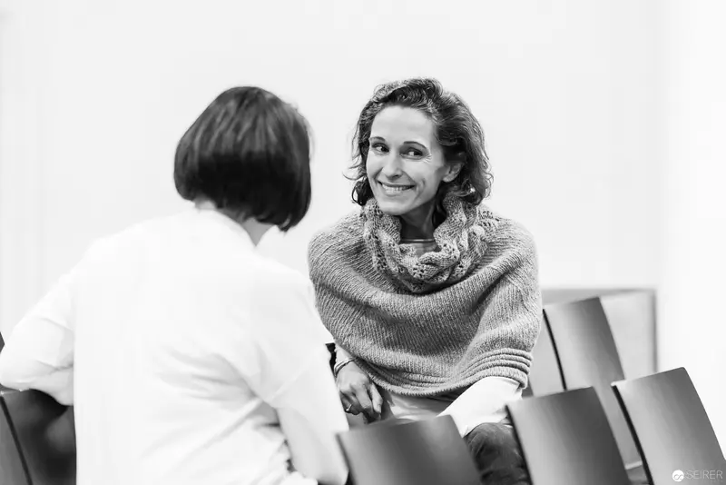 Melanie Laibl in Engaging Conversation, Seated in Professional Setting