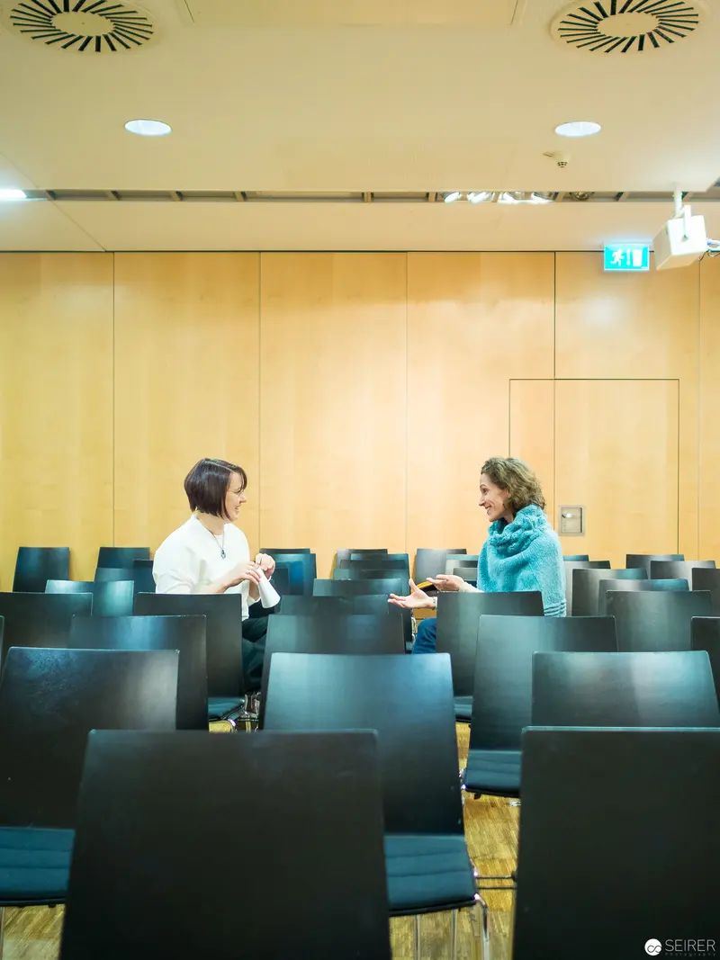 Two Professionals Conversing in Minimalist Conference Room Setting